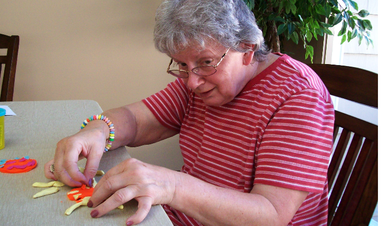 Roberta works on a project at the SeniorCare Homes Foster house